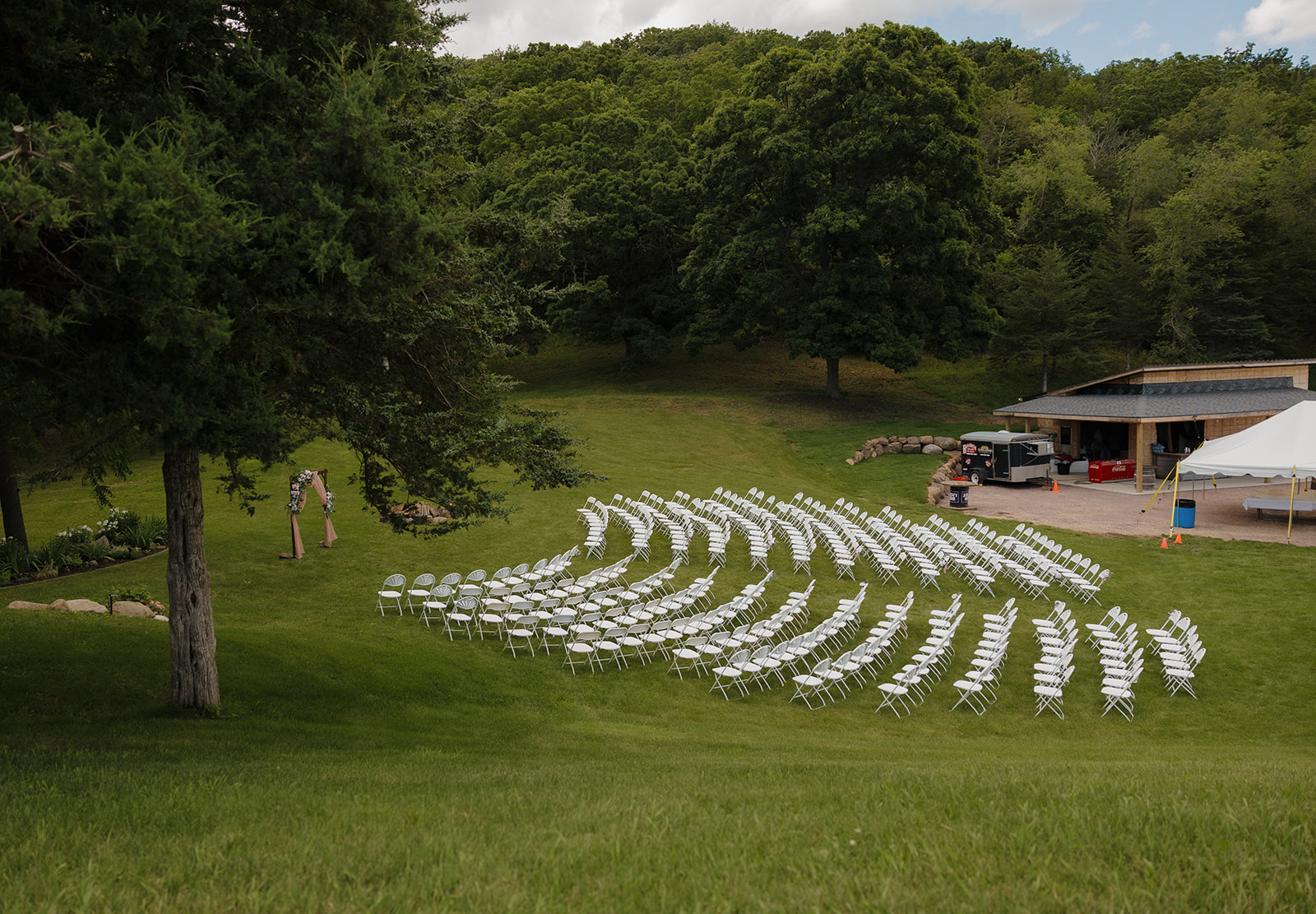 Hillside ceremony seating nestled within the trees at a vineyard wedding.