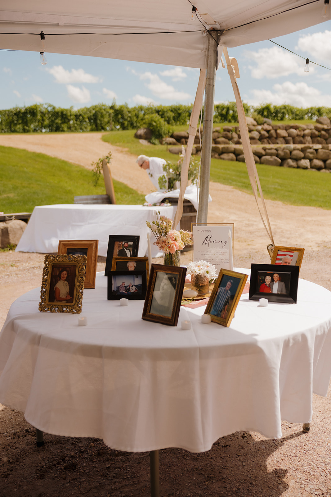 Honoring loved ones with a memory table beneath the tent at a winery wedding.