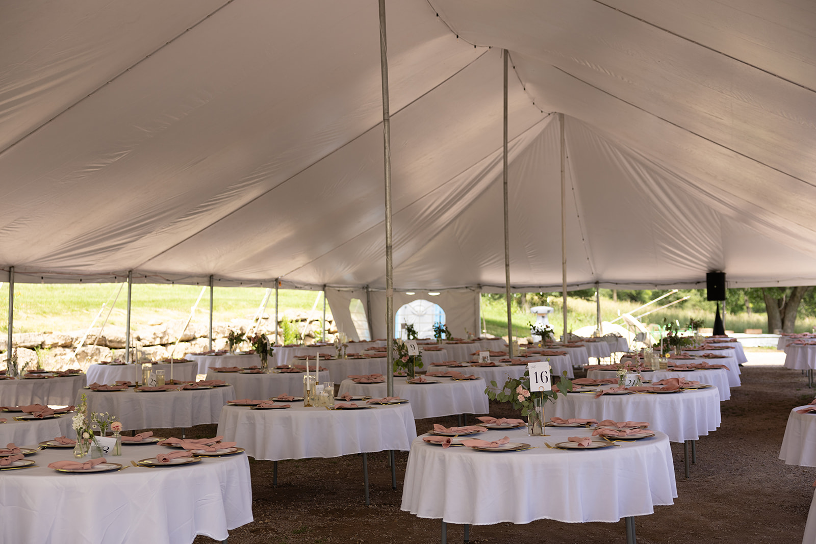 Romantic tented reception space at a Wisconsin winery wedding venue, set with blush accents.