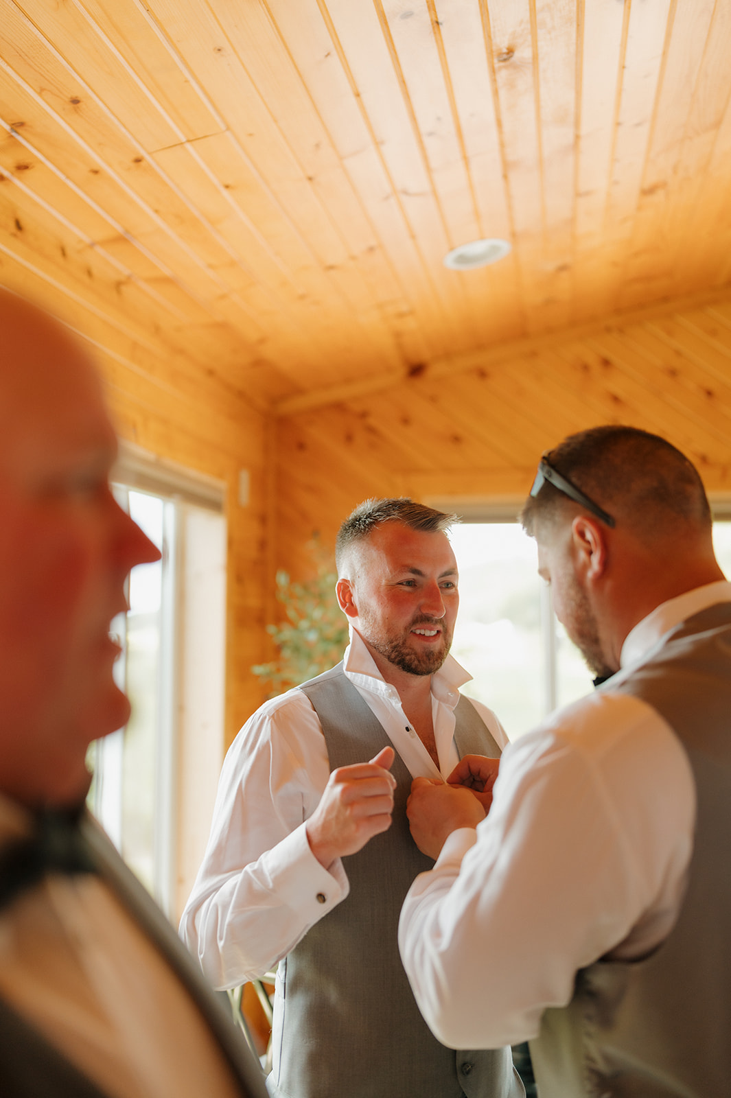 Groomsmen help each other get ready before the big vineyard ceremony.
