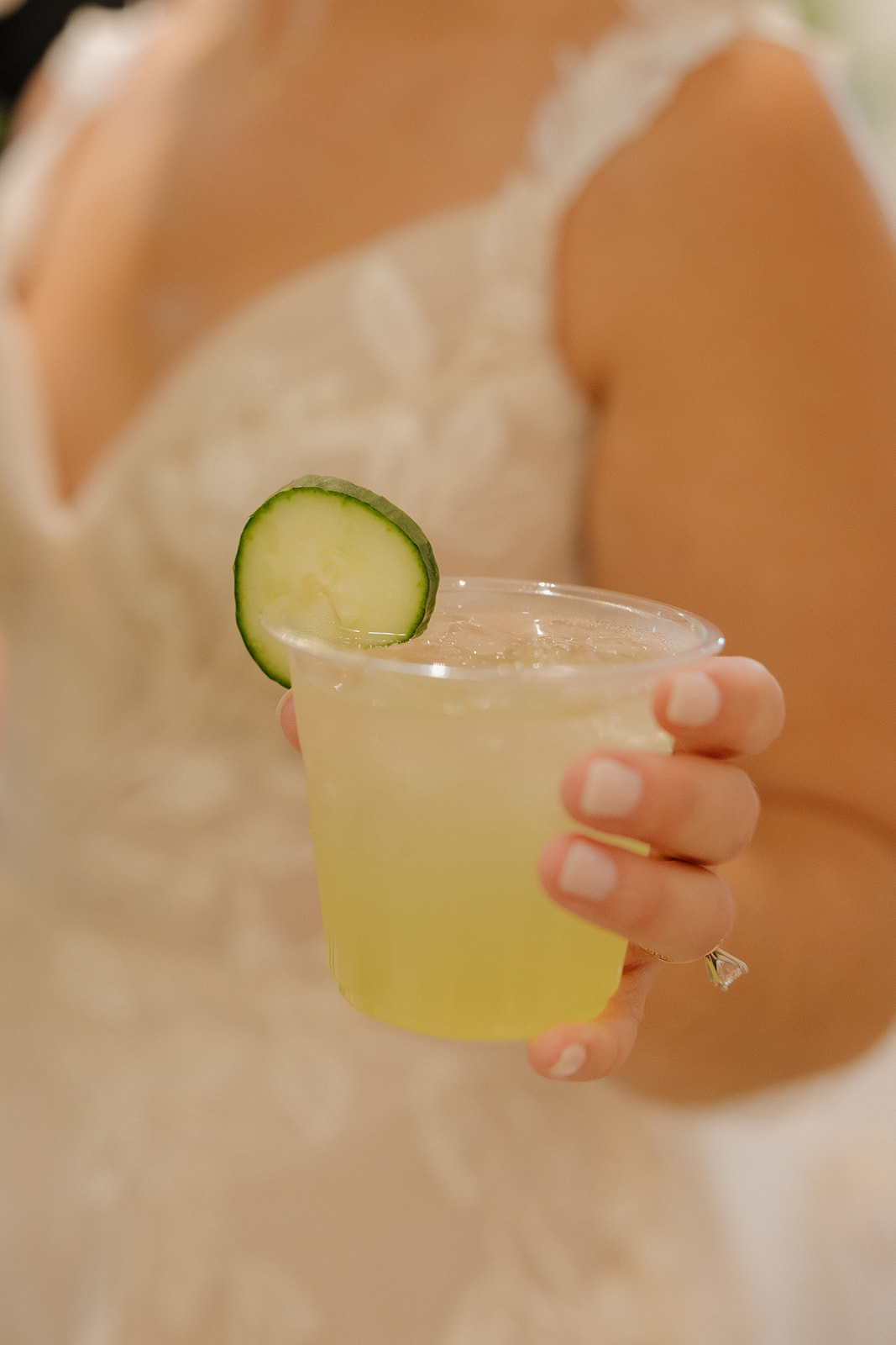 A bride in lace holds a fresh cucumber cocktail—proof that intentional details make every photo sparkle.