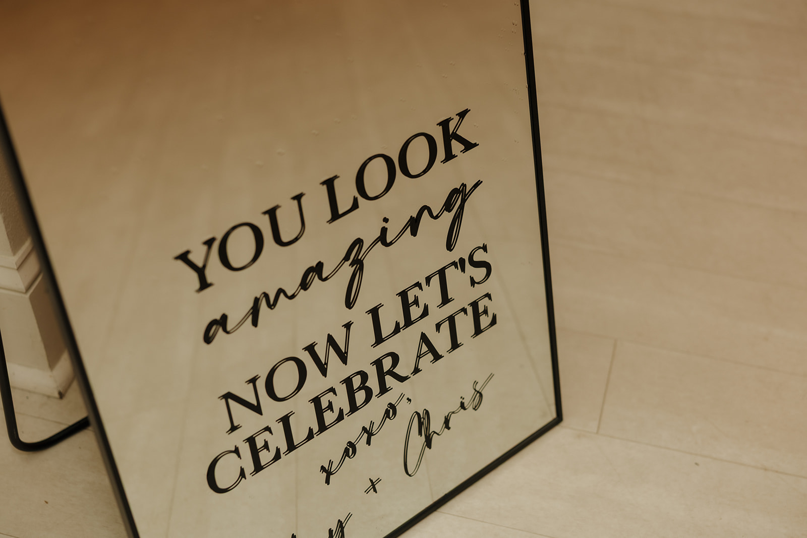 A stylish mirror sign greets guests with a playful message before the party begins.