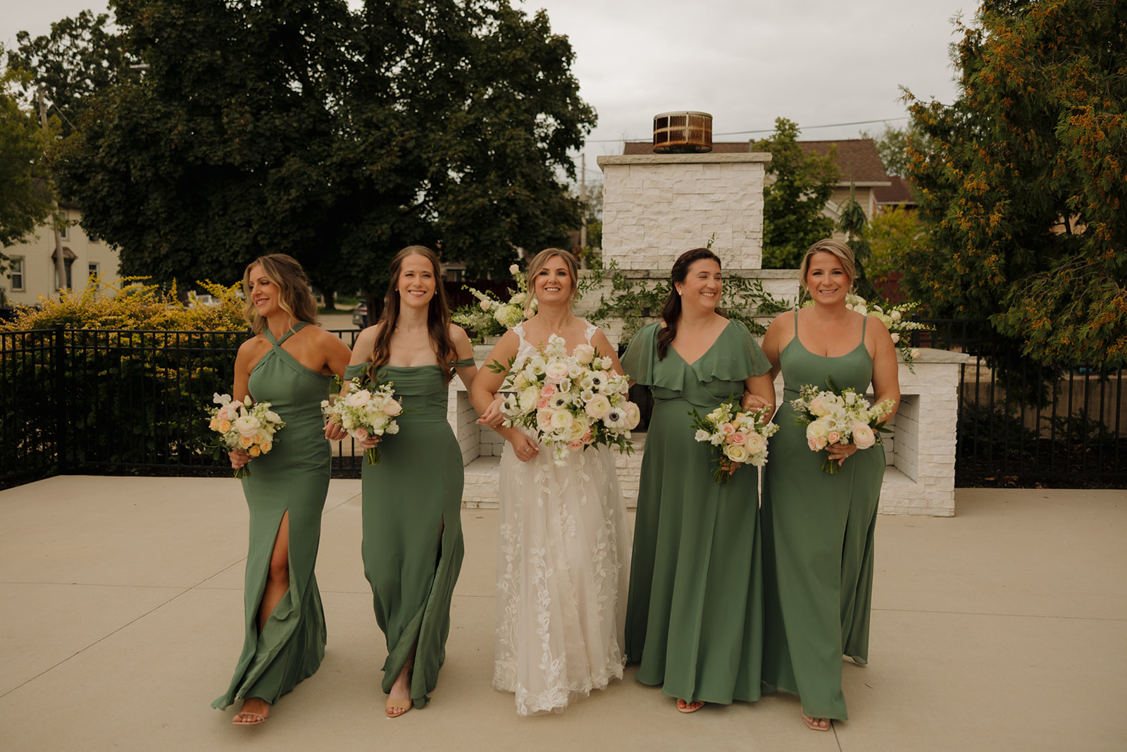 The bride walks arm-in-arm with her bridesmaids, bouquets in hand and genuine joy on their faces—documented beautifully by wedding photographers in Wisconsin.