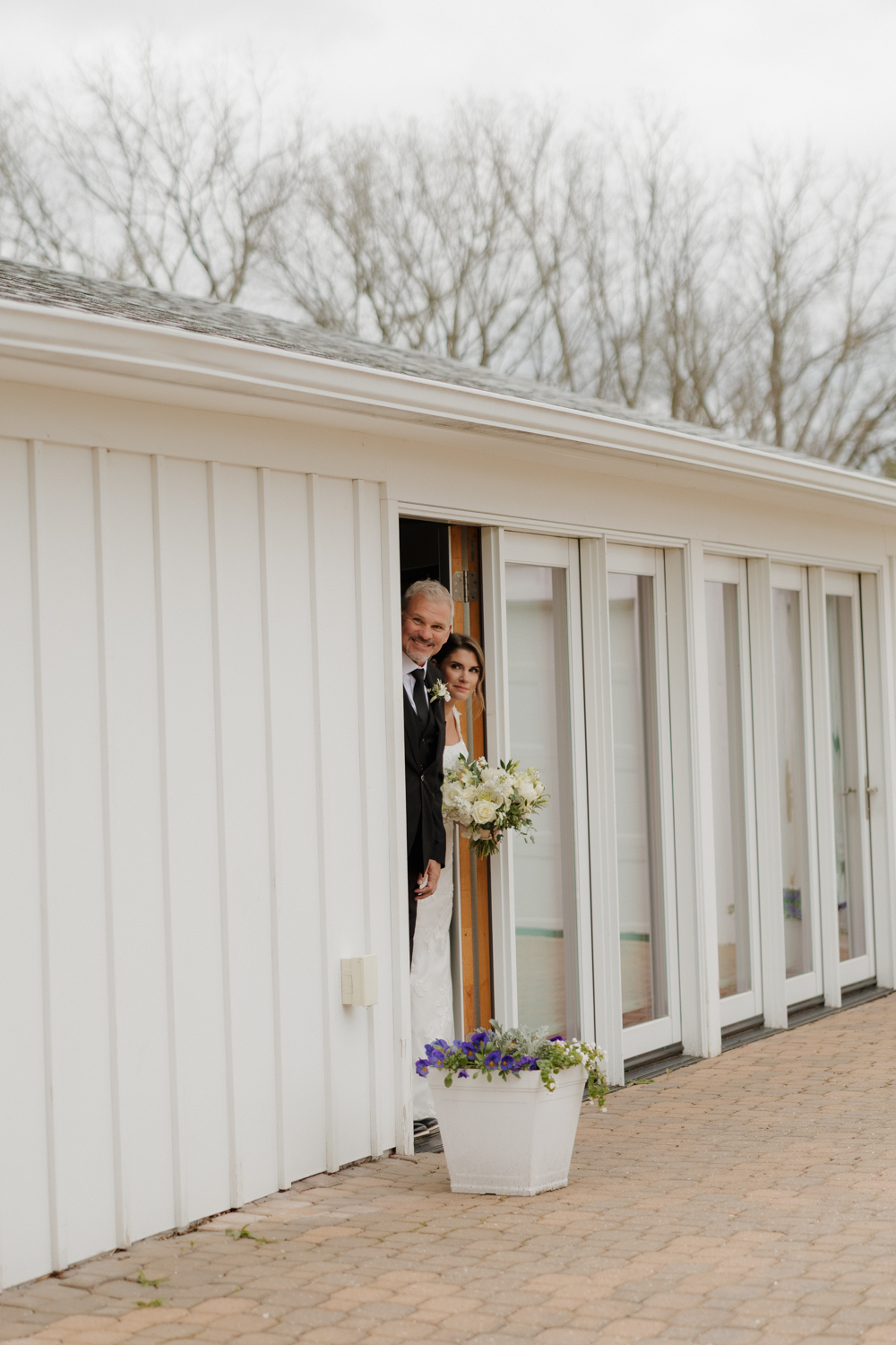 Bride and her father peeking out of the doorway at Boxed and Burlap Delavan before walking to the ceremony.