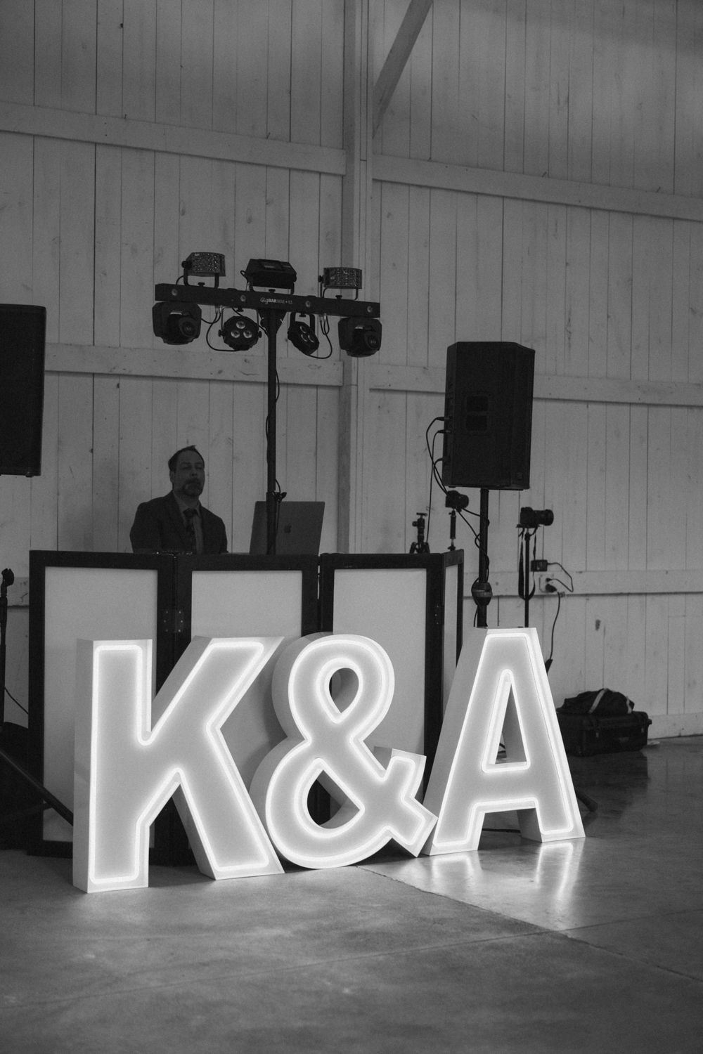 Illuminated marquee initials in front of the DJ booth during the reception at Boxed and Burlap Delavan.