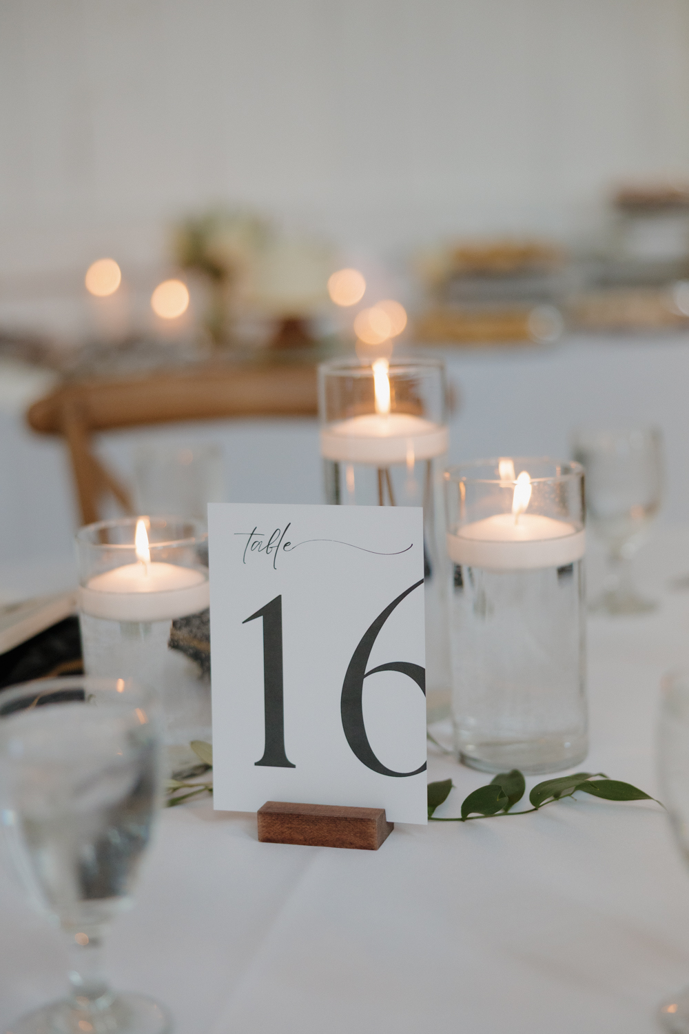 Reception table detail with floating candles and modern table number design at Boxed and Burlap Delavan.
