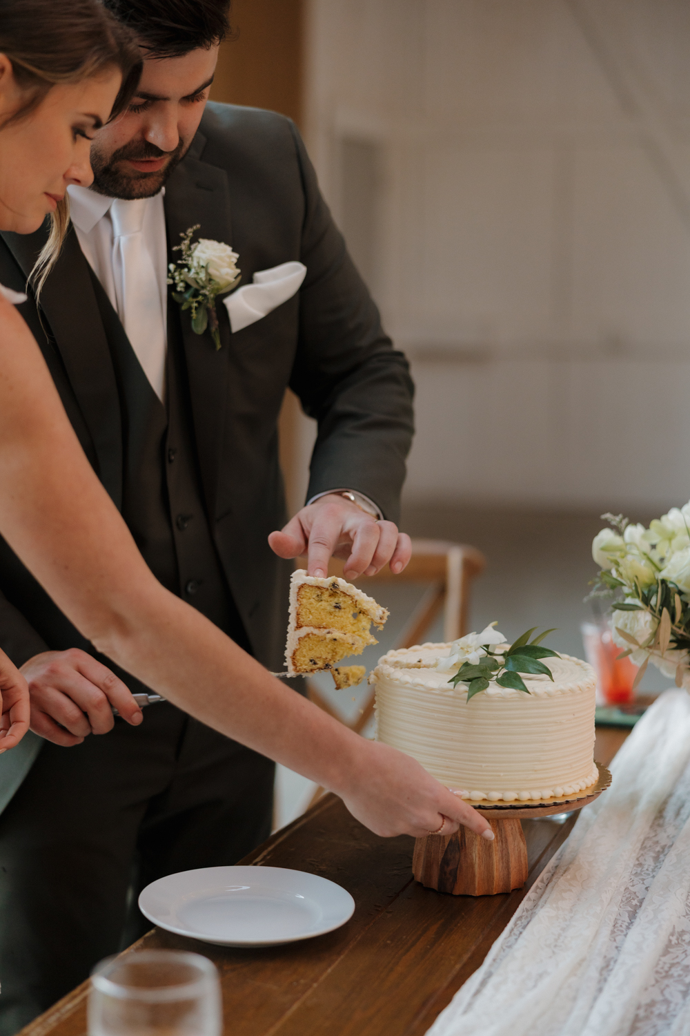 Bride and groom cutting their wedding cake together during their reception at Boxed and Burlap Delavan.