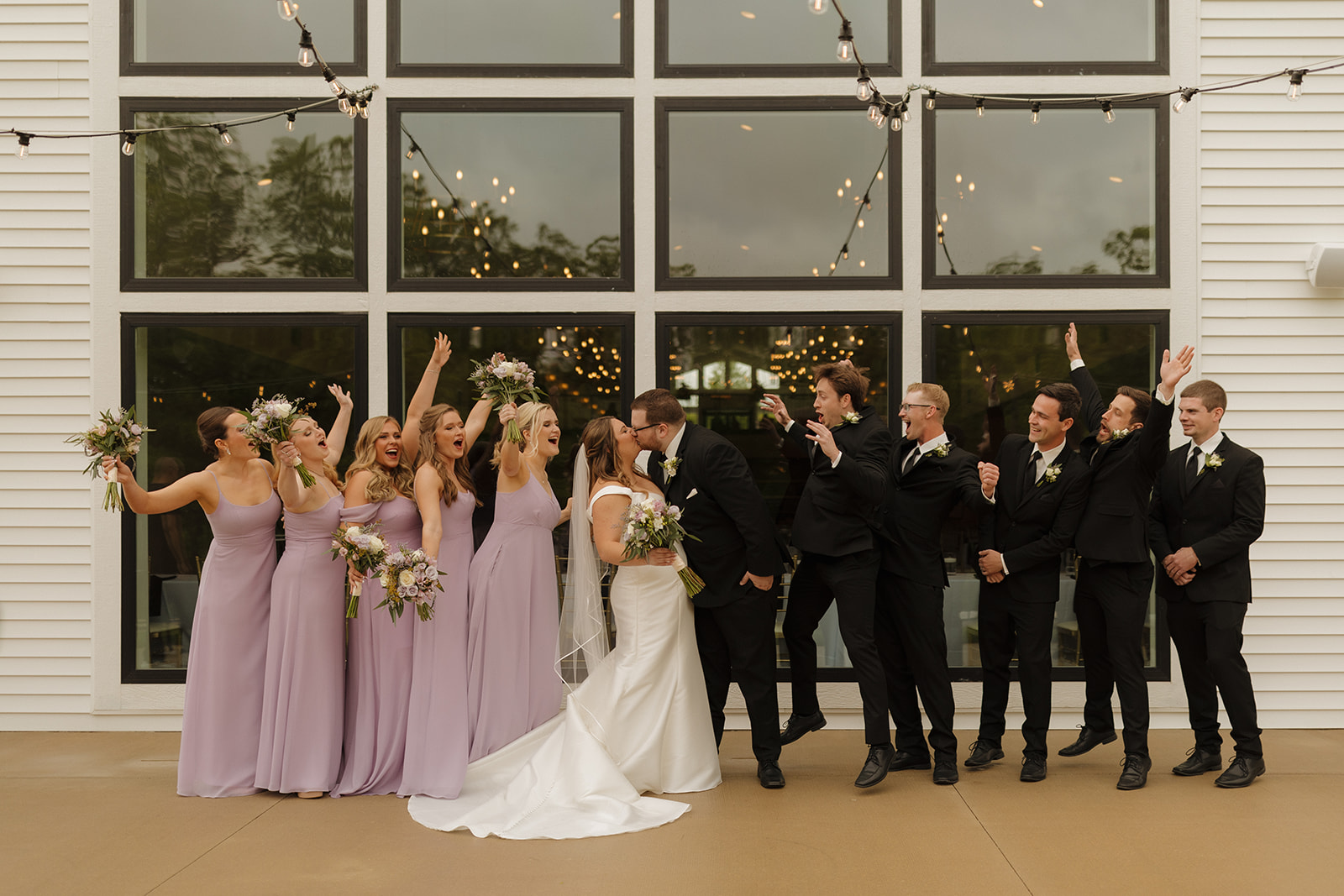 Full wedding party celebrating outside modern wedding venues in Wisconsin
