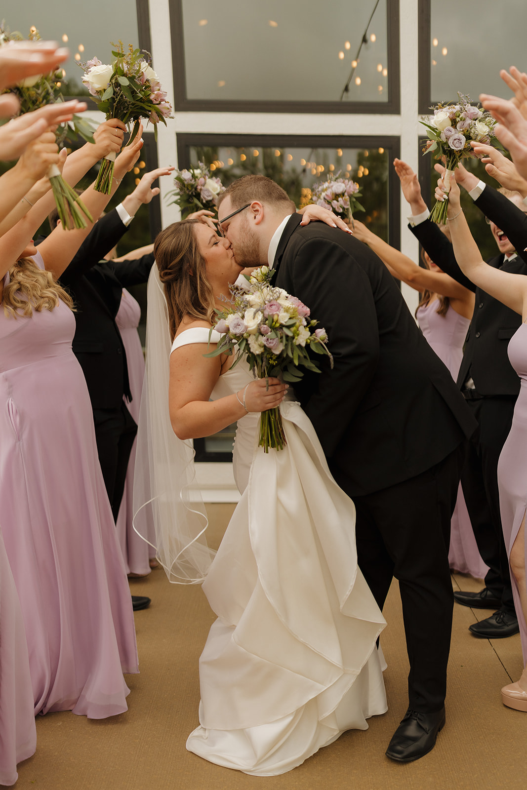 Wedding party cheering as couple kisses at a modern wedding venue in Wisconsin