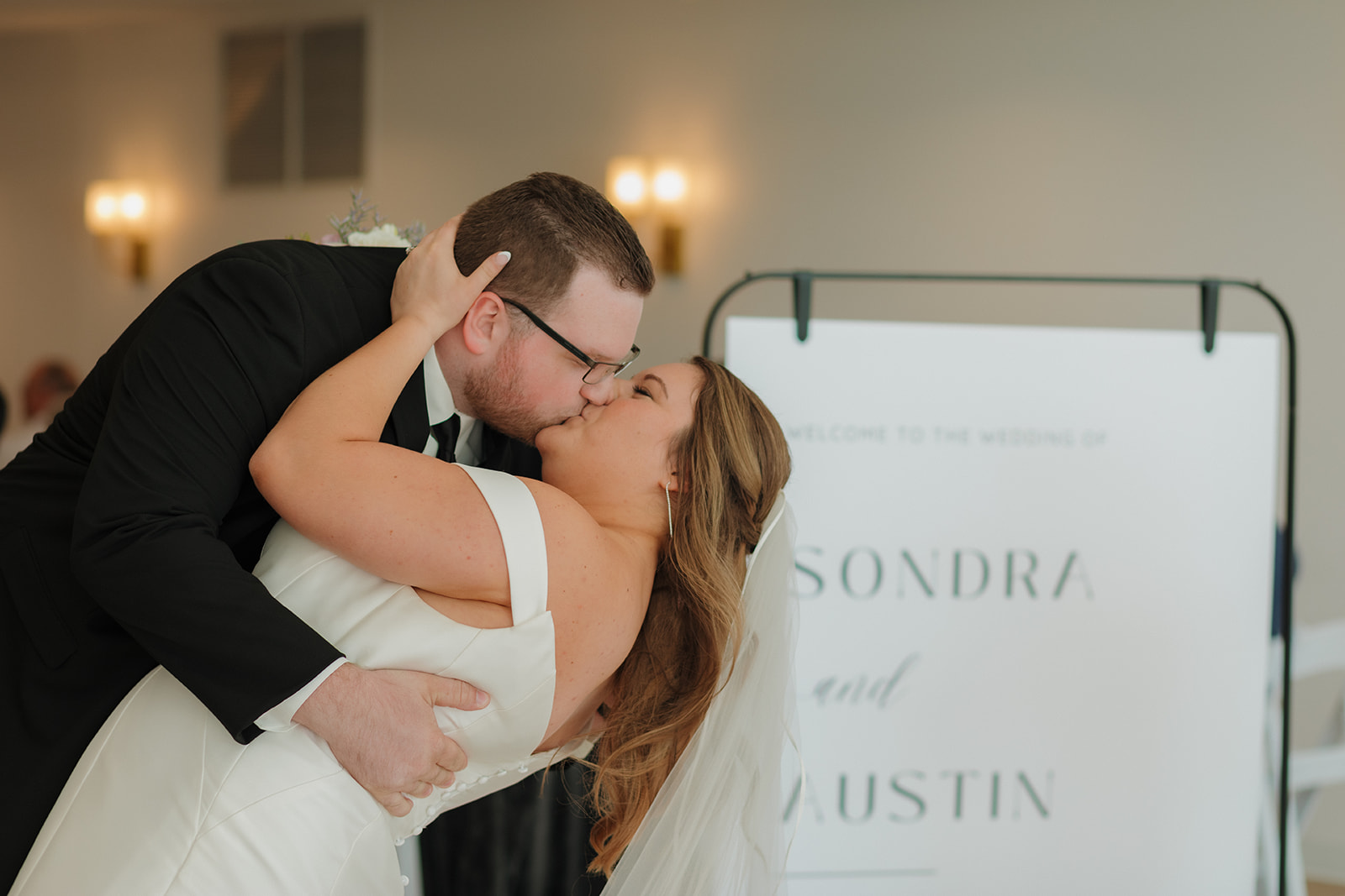Bride and groom sharing a romantic dip kiss during reception