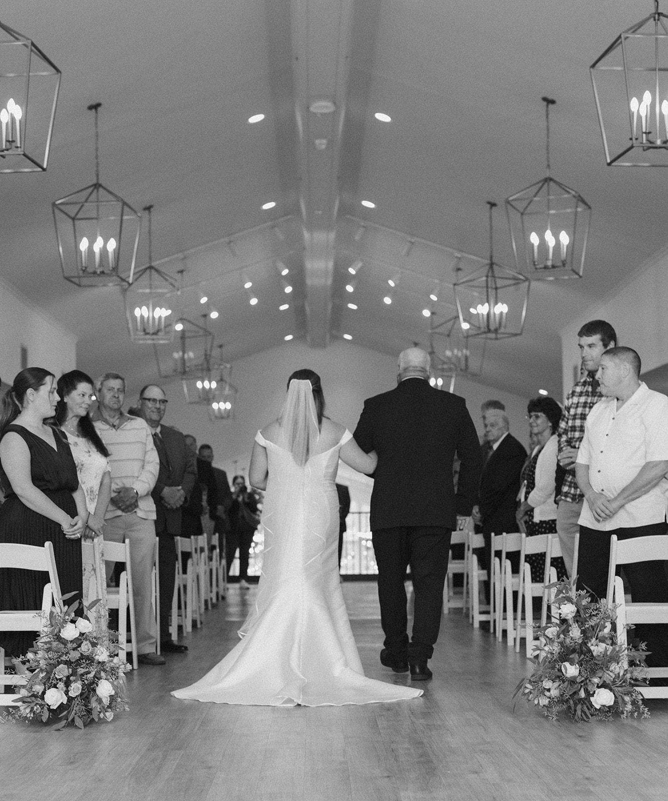 Bride walking down aisle with father in black and white at wedding venues in Wisconsin