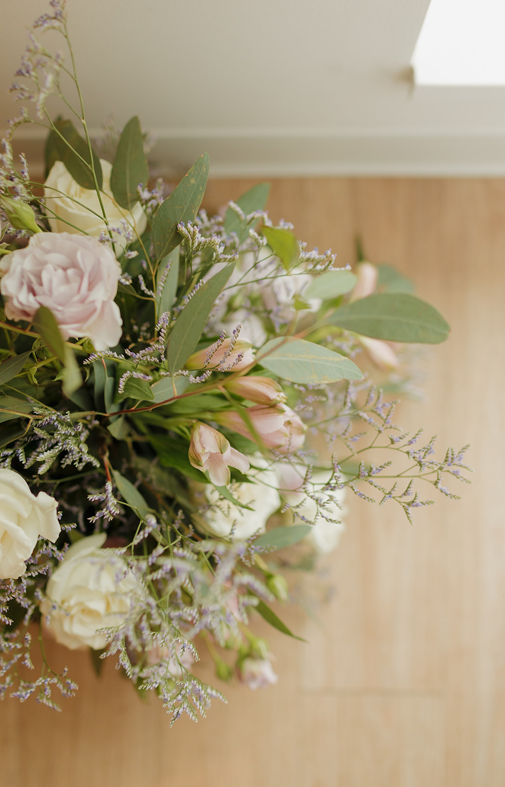 Soft pastel bridal bouquet with roses and greenery in natural light