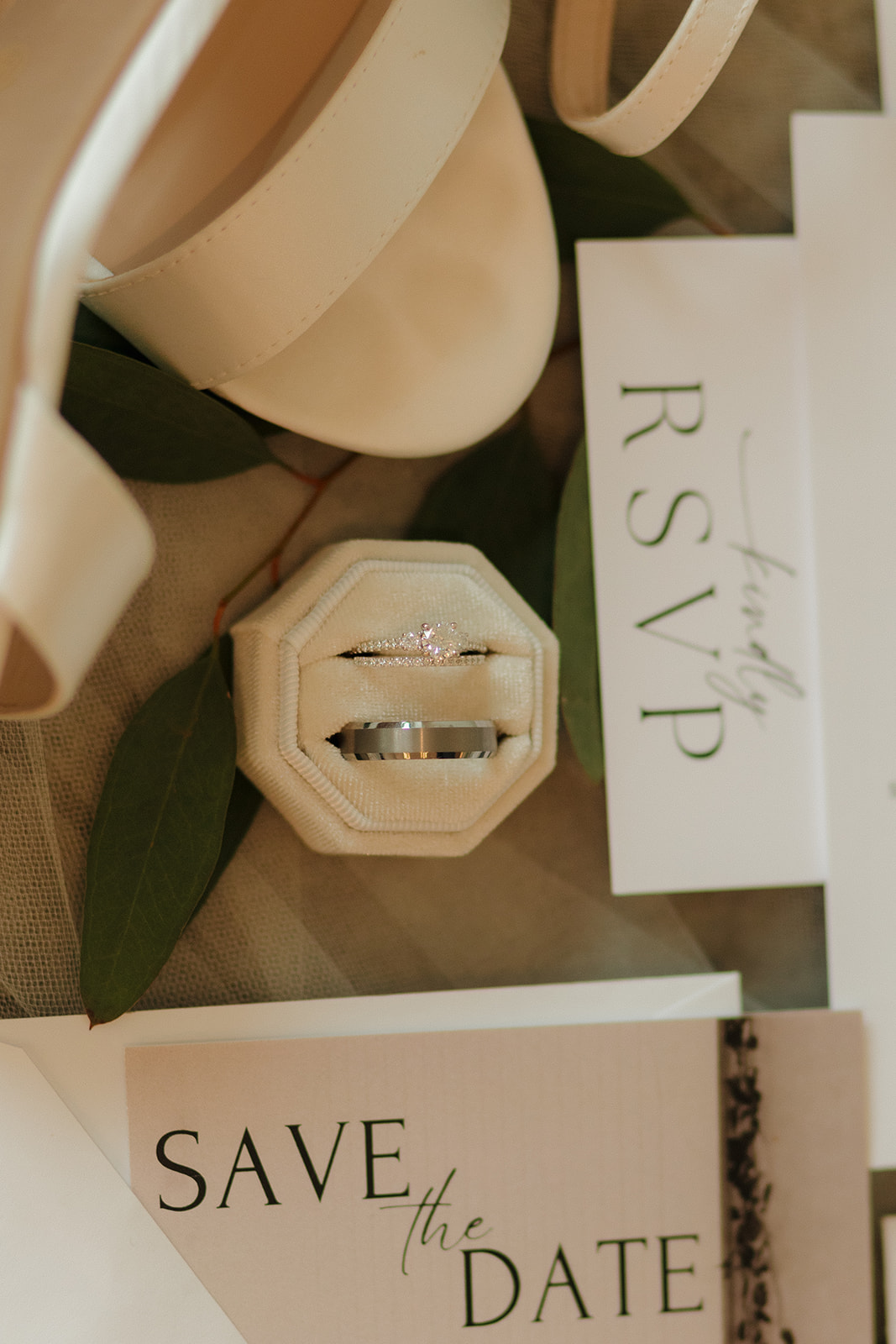 Wedding rings in velvet box styled with modern invitation suite and greenery