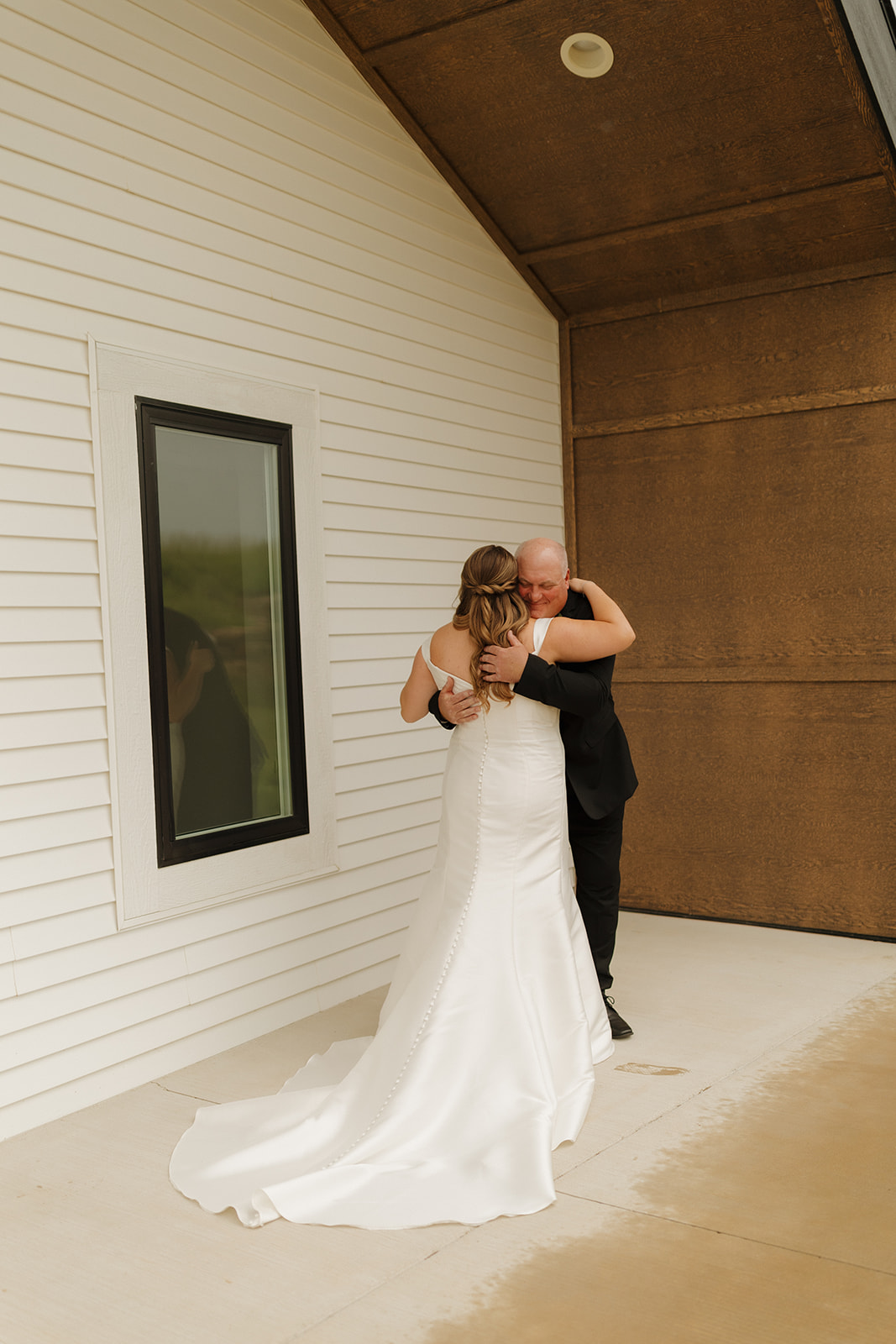 Bride and father embracing during outdoor first look moment