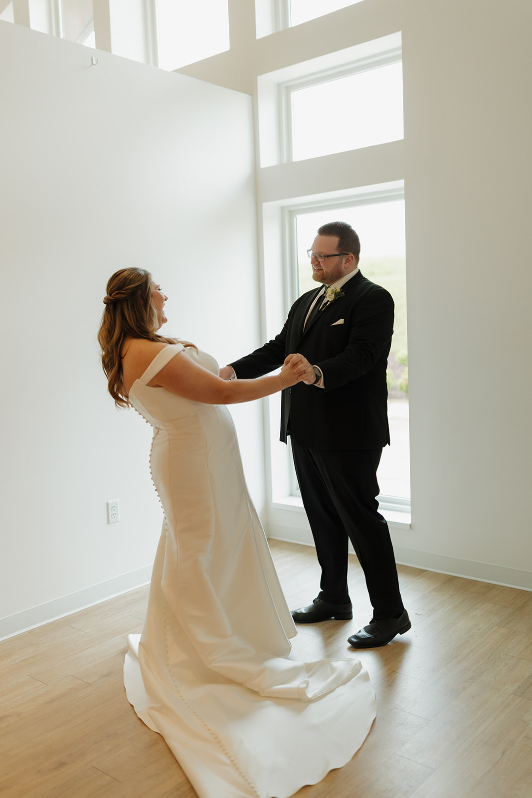 Bride and groom dancing in natural window light at modern wedding venues in Wisconsin