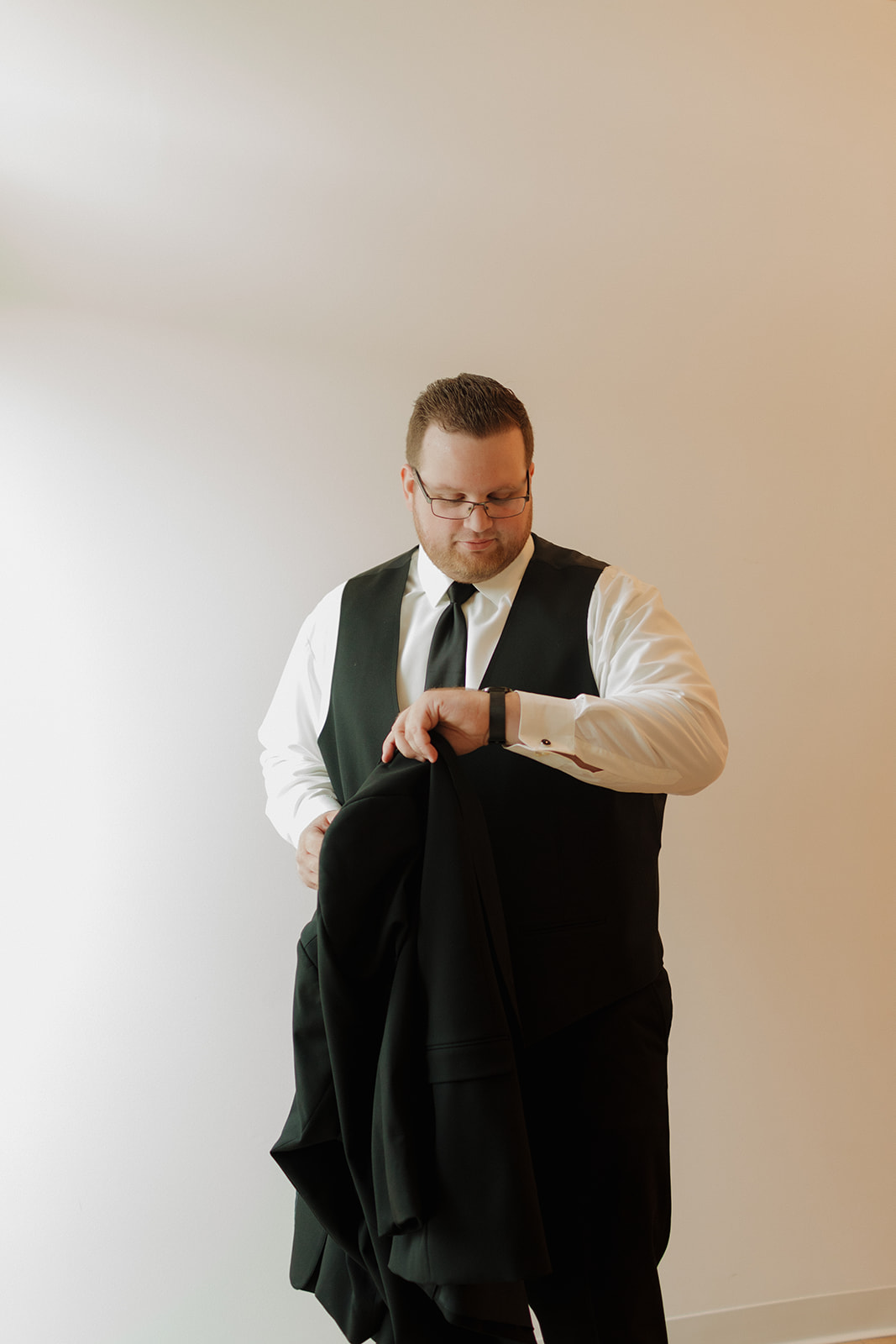 Groom checking his watch while getting ready at a Wisconsin wedding venue