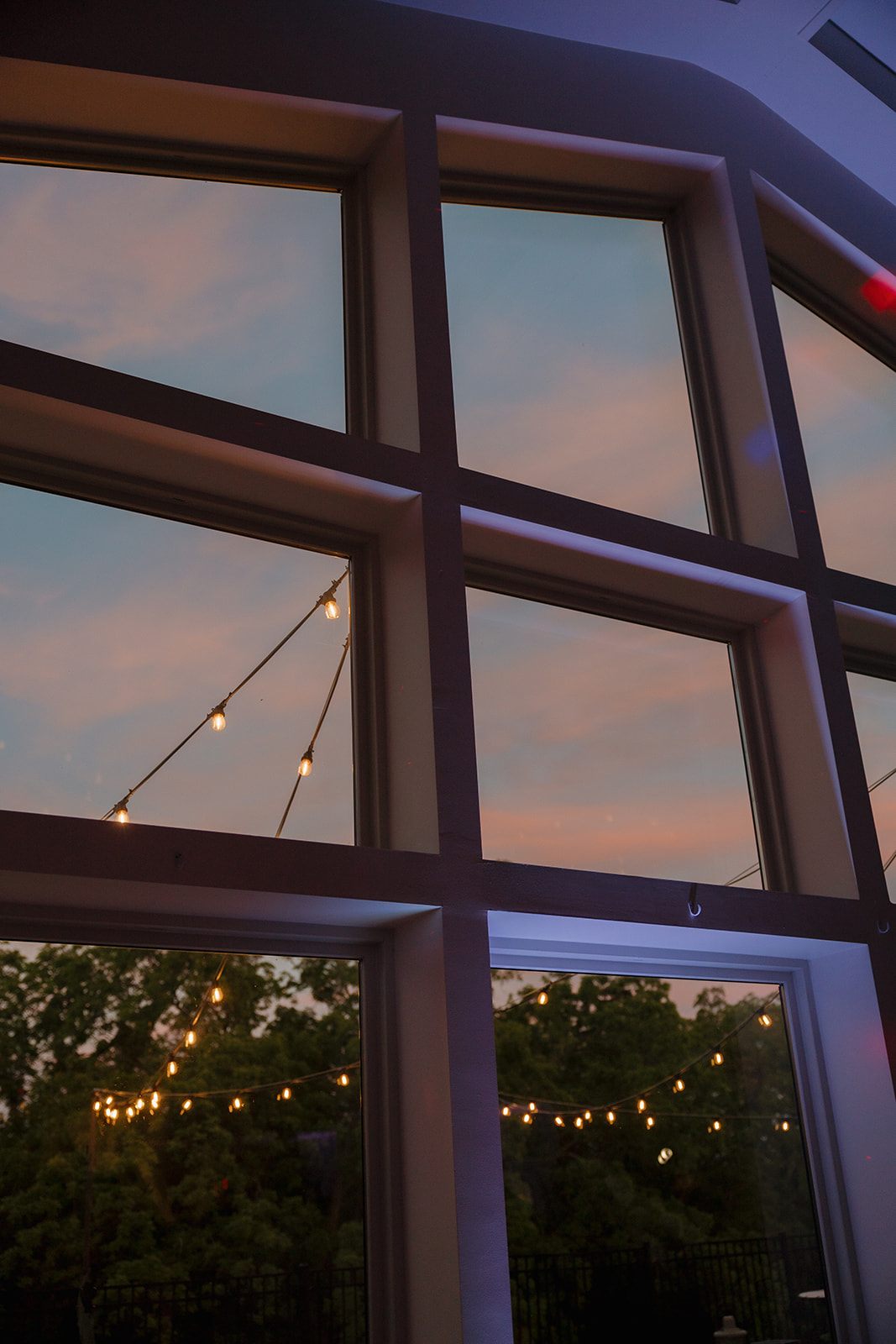 Large architectural windows reflecting sunset at modern wedding venues in Wisconsin