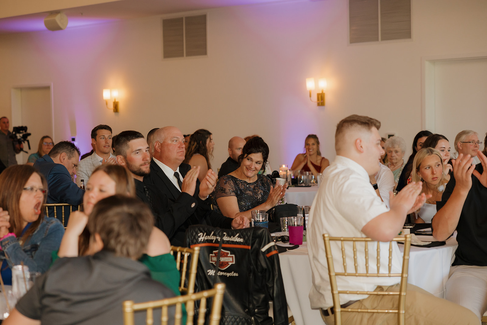 Wedding guests applauding during reception inside modern wedding venues in Wisconsin