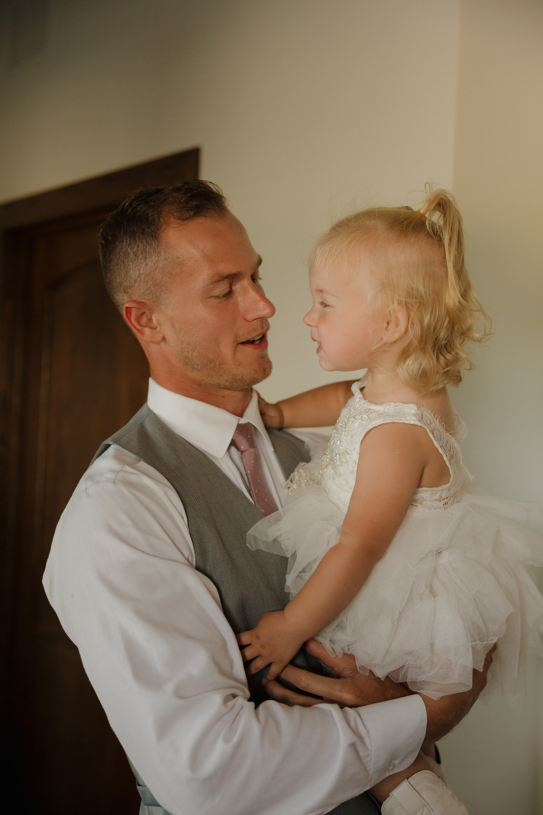 Groom holding his daughter in a quiet getting ready moment before the ceremony.
