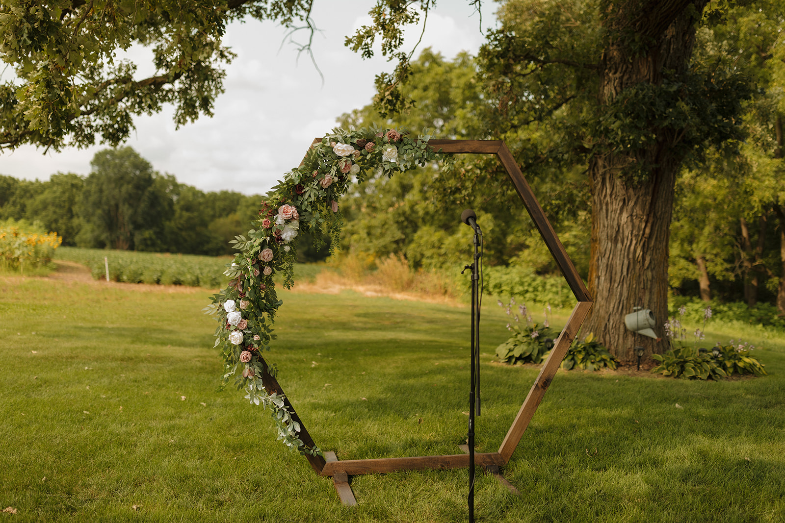 Hexagon floral ceremony arch set up outdoors at Prairie Creek Farm—an ideal setting for your wedding photography checklist.