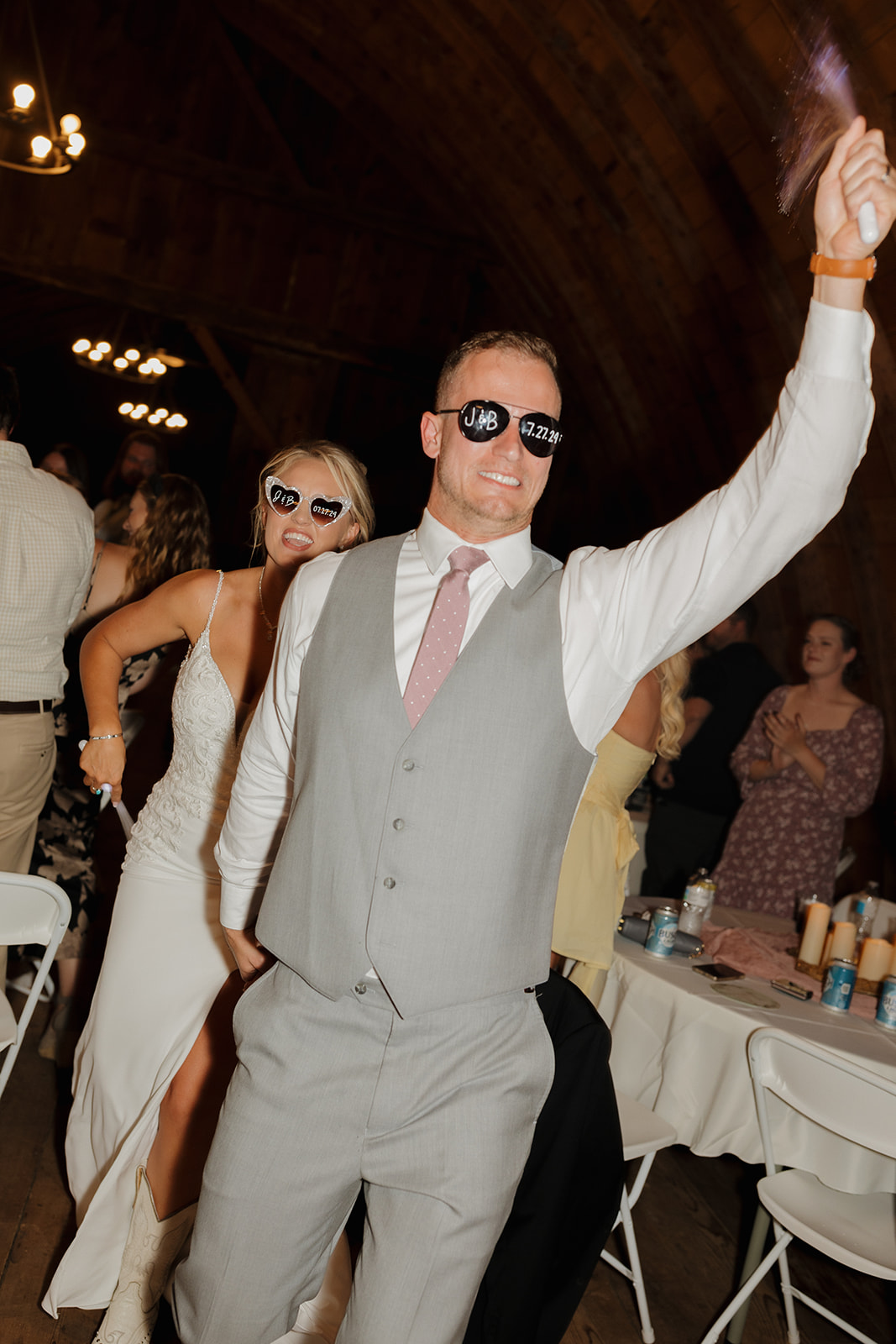 Bride and groom dance through the reception in celebration, guests cheering them on.