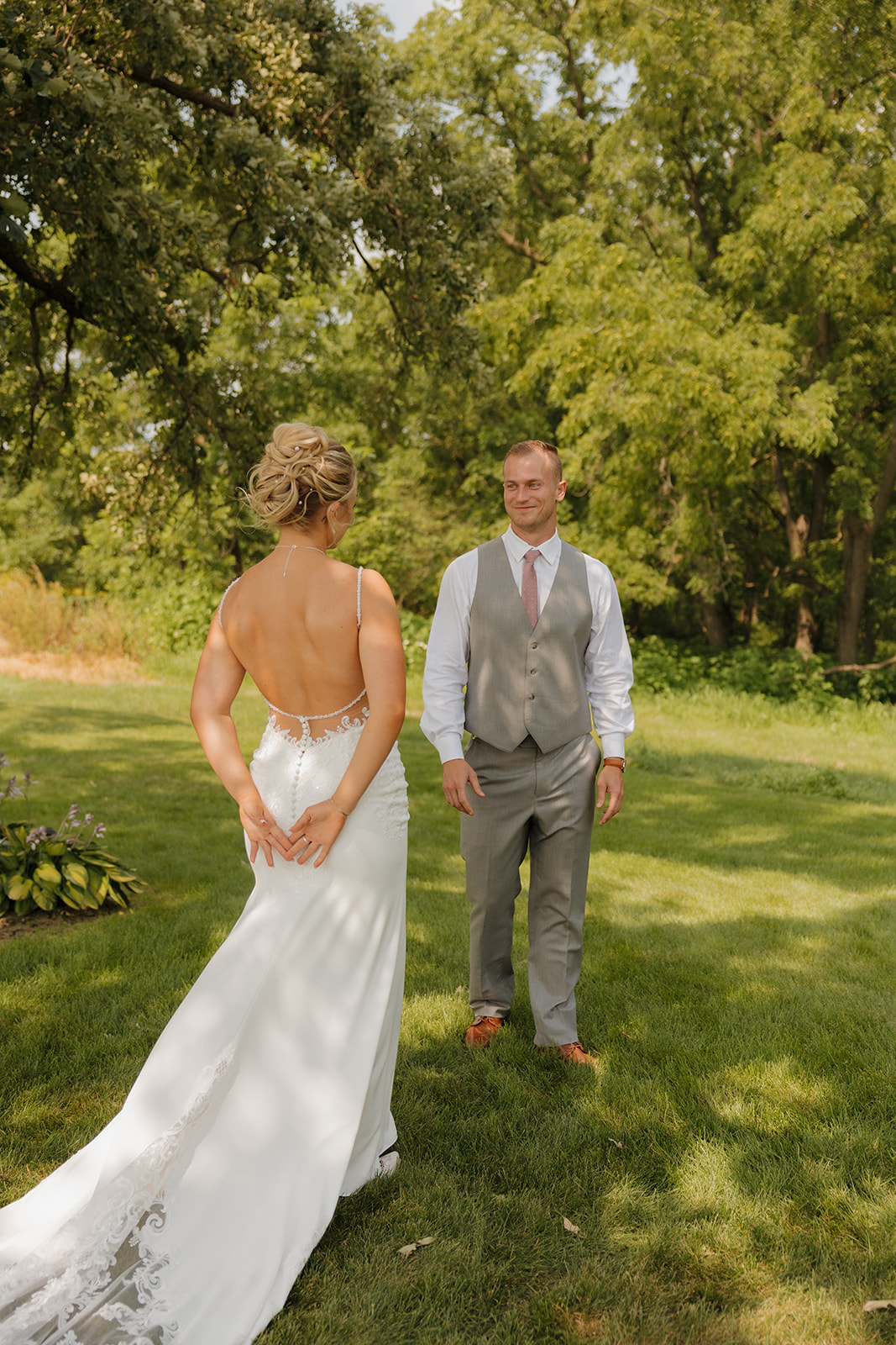 Groom smiling as he sees his bride for the first time during their first look—timeless and emotional.