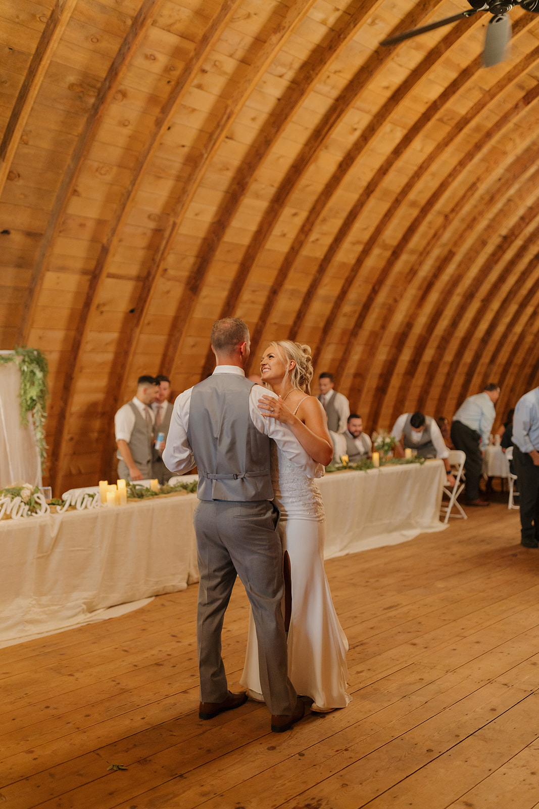 The couple shares their first dance beneath the arched wooden ceiling—an essential wedding photography checklist moment.