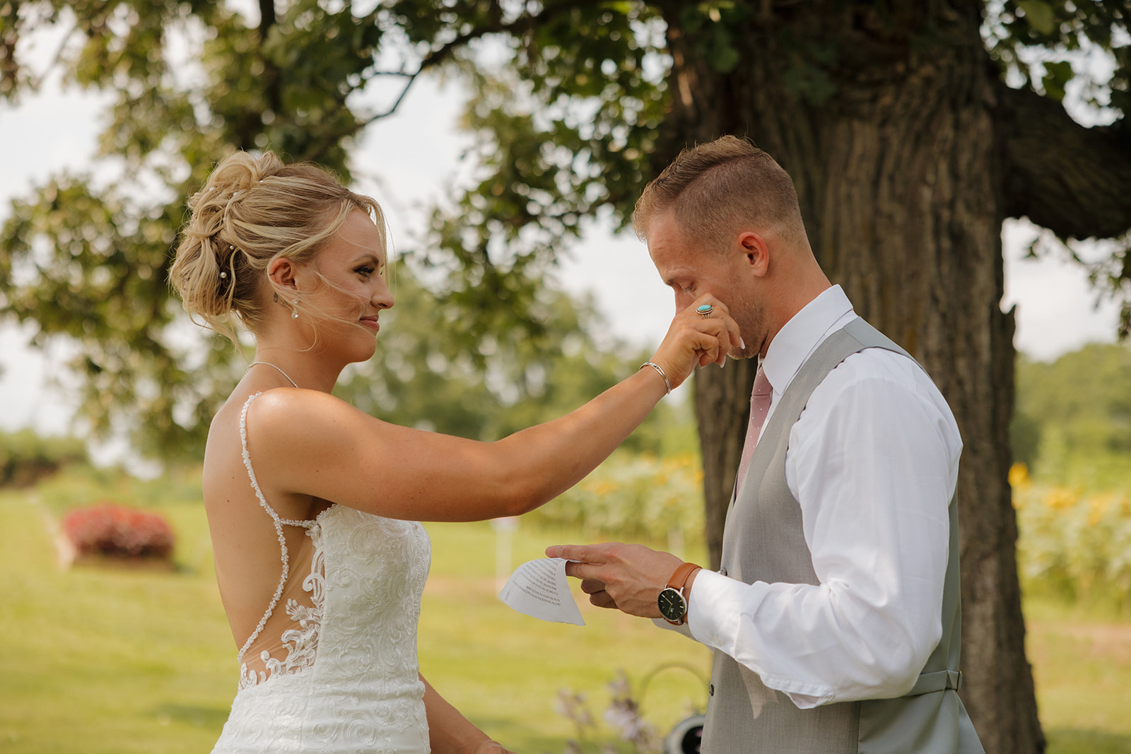Bride wiping a tear from the groom’s face during personal vow exchange, a key moment on any wedding photography checklist.