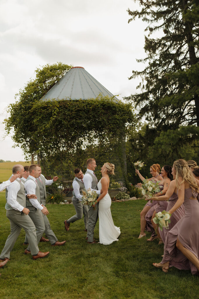 Wedding party running toward each other on a lush lawn—real moments included in a wedding photography checklist.