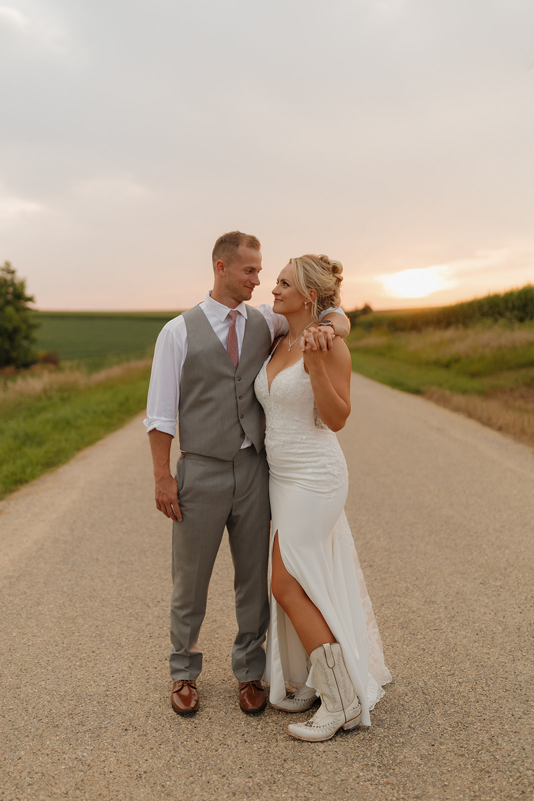 The bride and groom share a quiet moment at sunset on a country road—timing like this belongs on your wedding photography checklist.