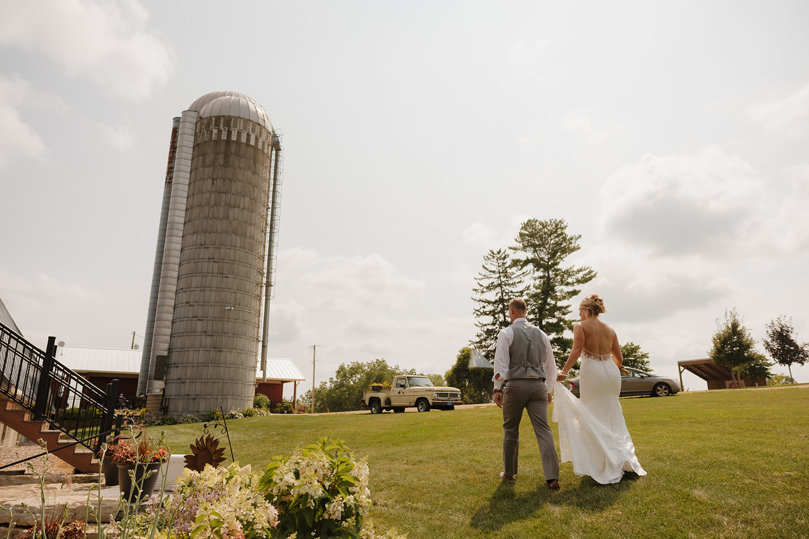 Bride and groom walking toward the barn silo at Prairie Creek Farm, captured as part of their wedding photography checklist.