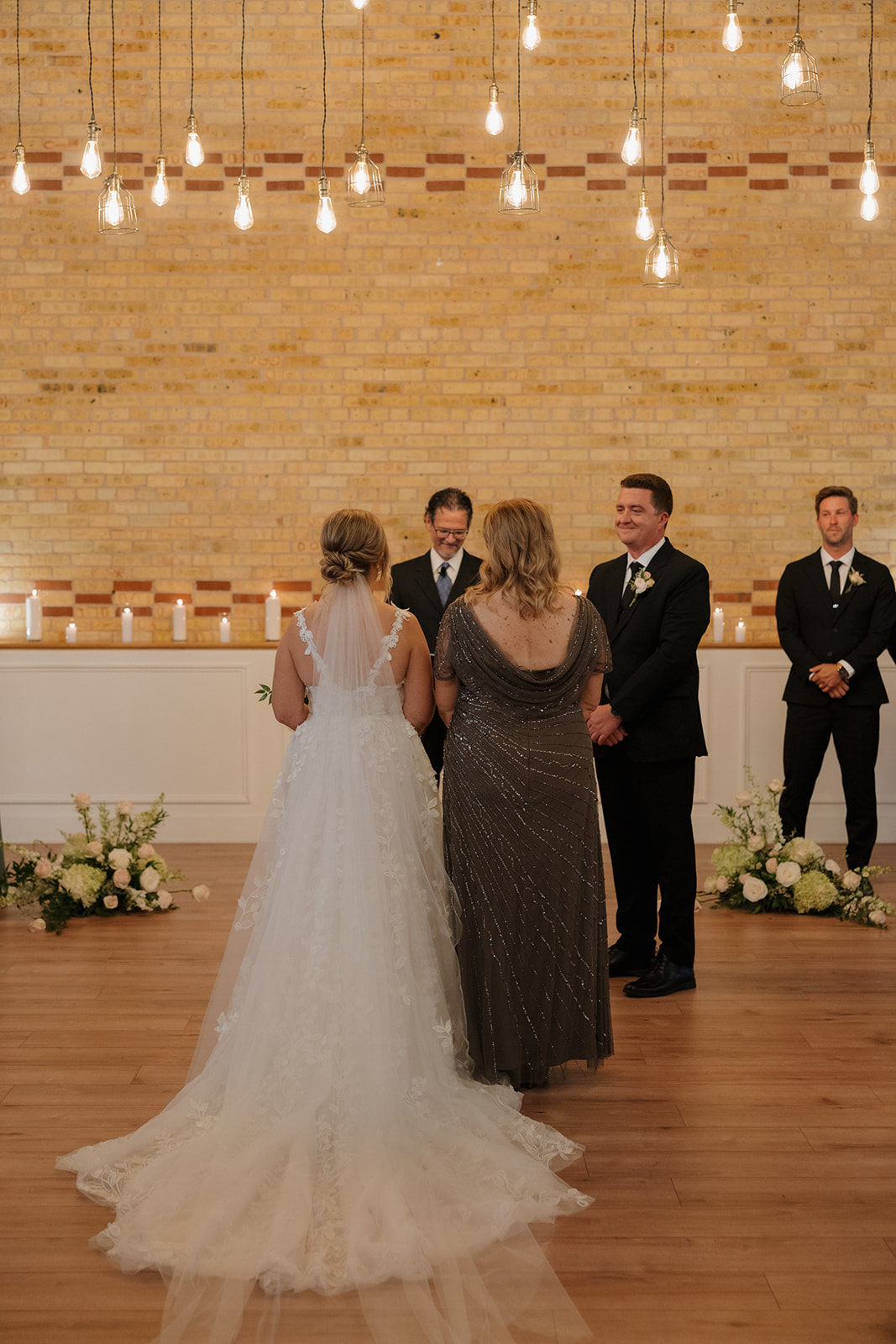 Indoor wedding ceremony with hanging lights inside a modern industrial wedding venue in Fort Myers