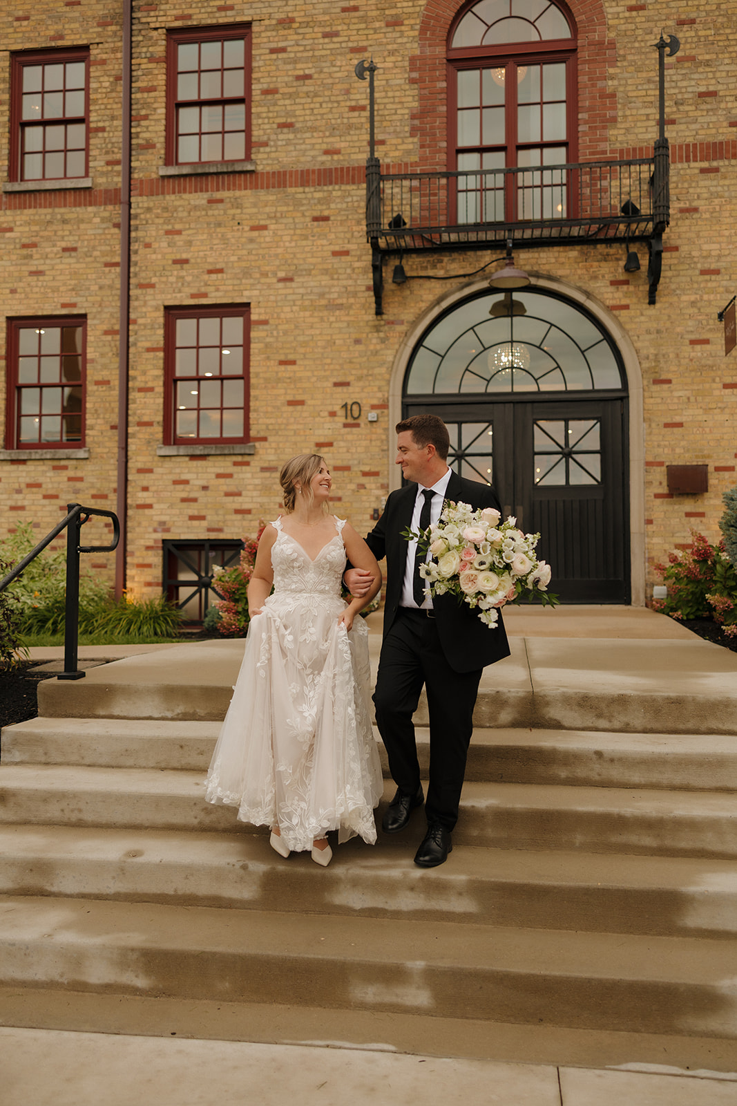 Bride and groom walking down steps outside a historic venue often featured among wedding venues in Fort Myers