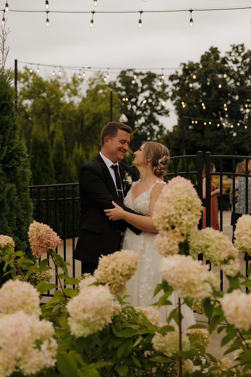 Romantic newlywed portrait beneath string lights at a garden-style wedding venue in Fort Myers Florida