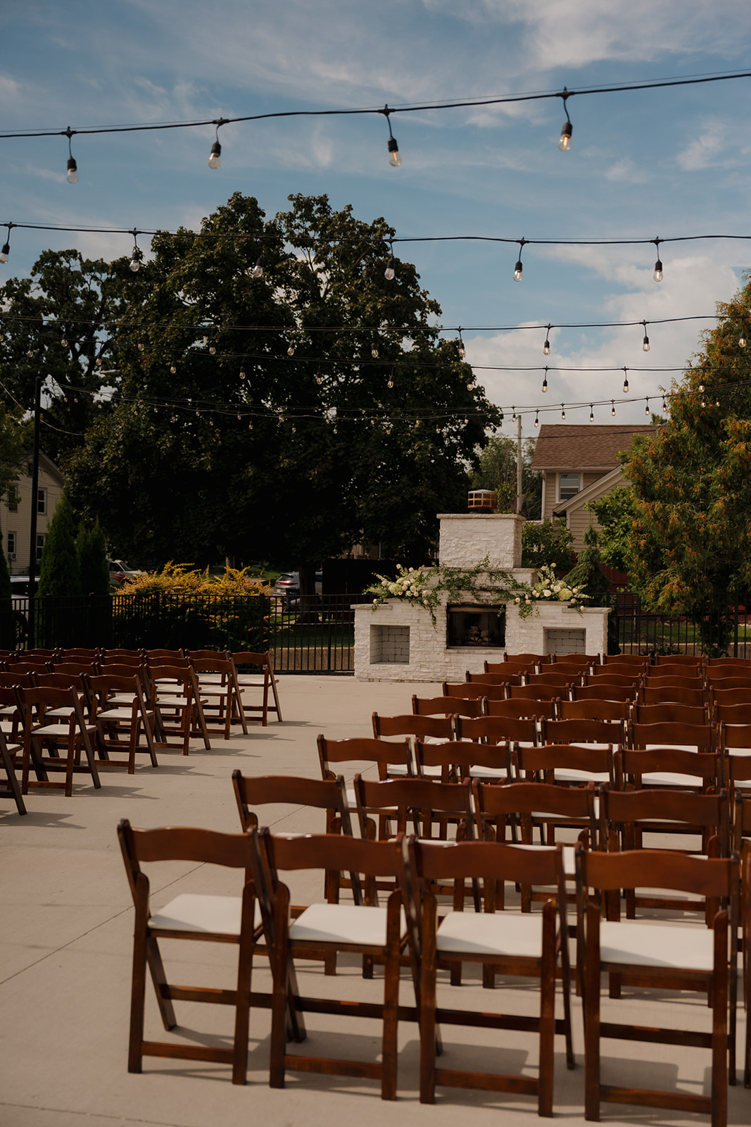 Outdoor ceremony setup with wooden chairs and string lights at one of the most charming wedding venues in Fort Myers