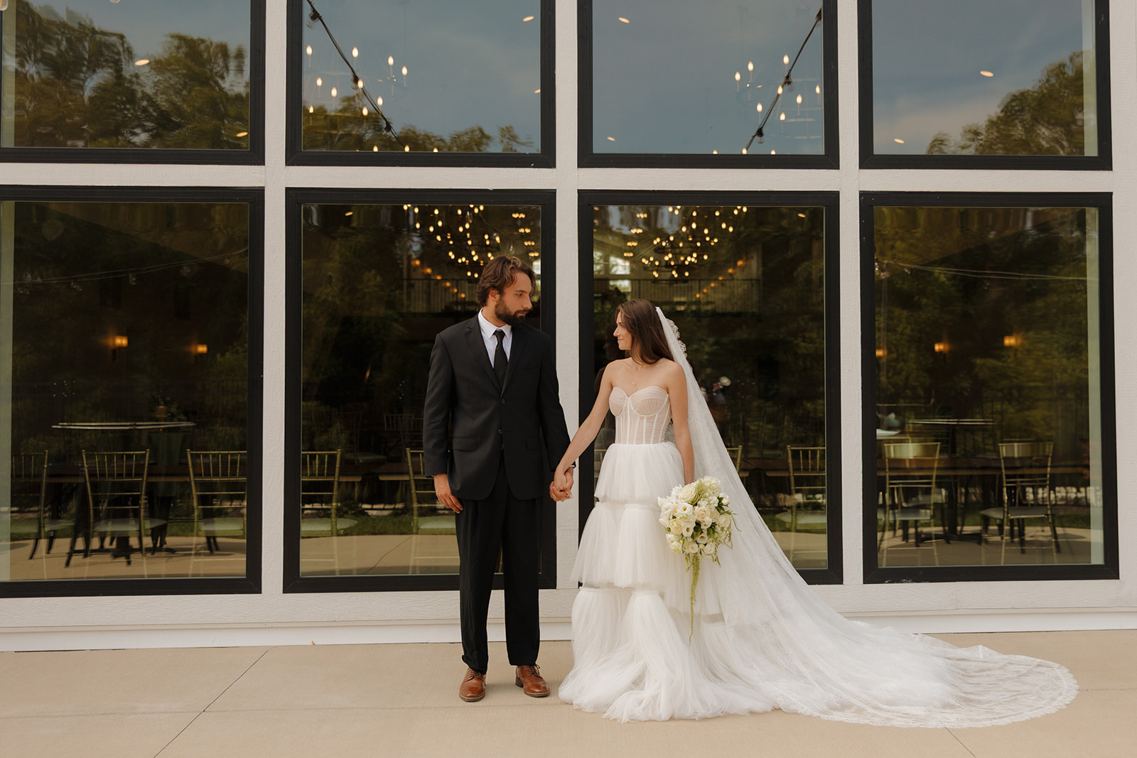 Bride and groom holding hands outside a modern reception space at one of the contemporary wedding venues in Fort Myers