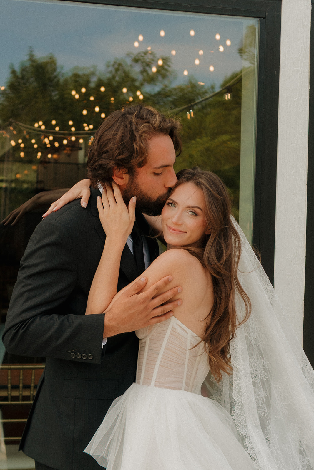 Newlywed couple embracing outside a contemporary reception space at one of the stylish wedding venues in Fort Myers