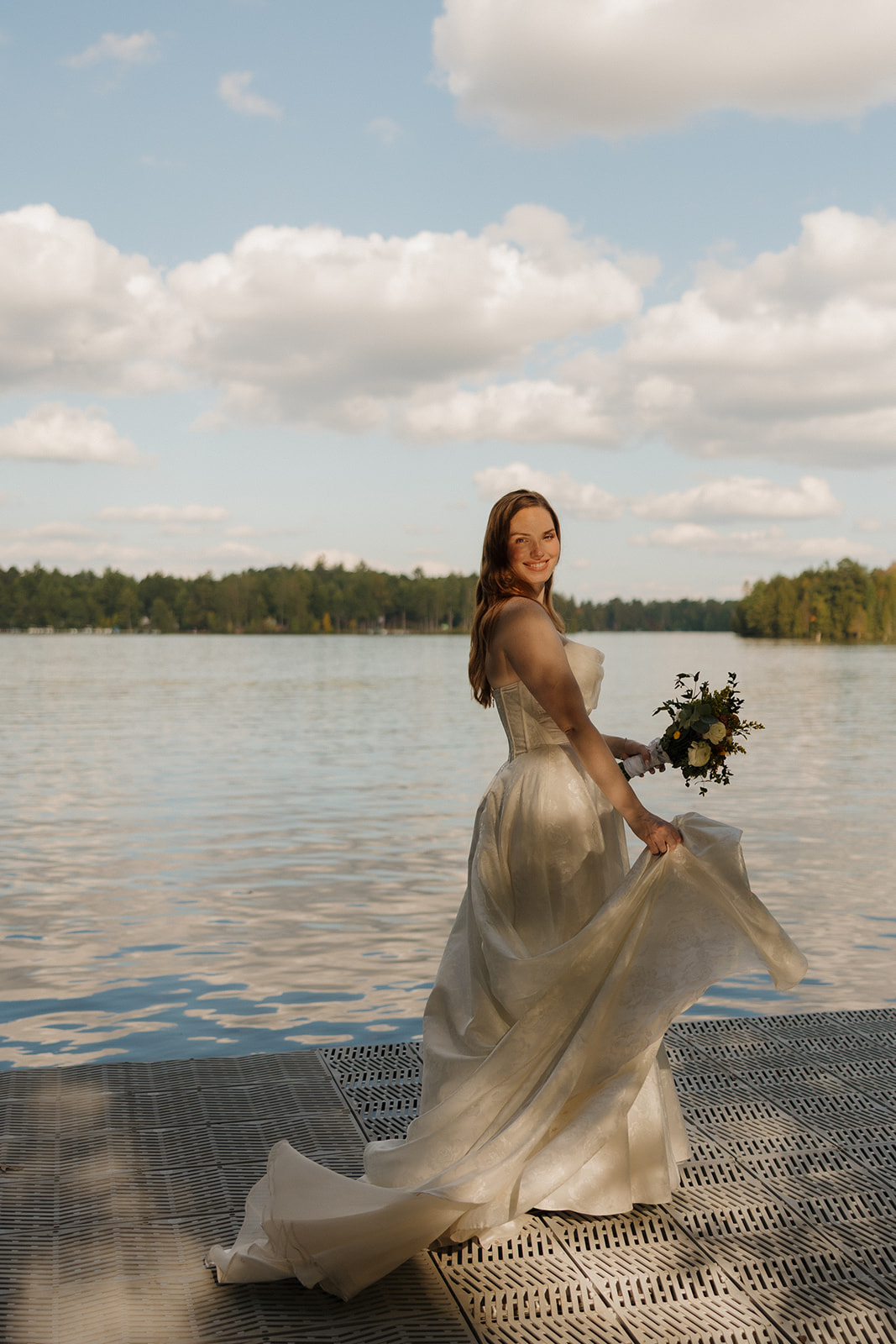Bride standing on a dock with lake views during golden hour bridal portraits