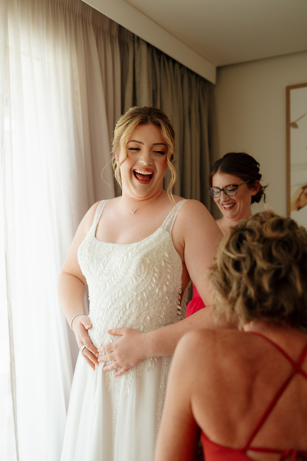 Bride laughing with bridesmaids while getting ready for a wedding in Florida
