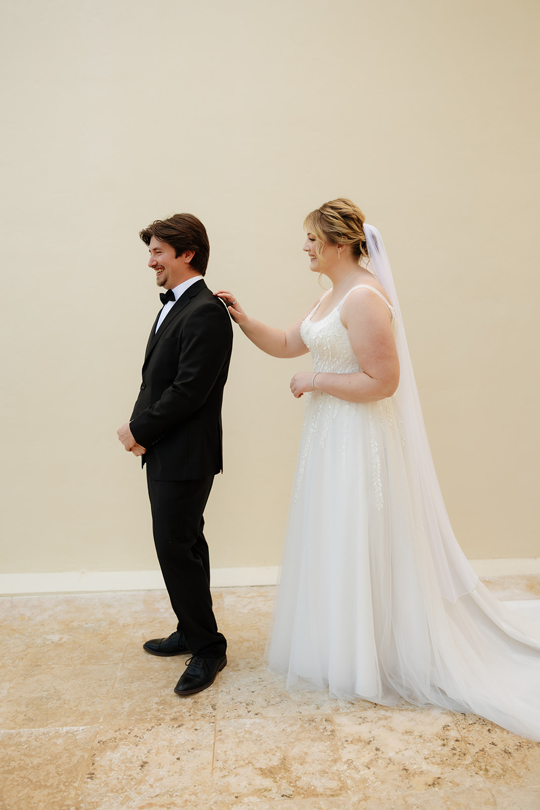 Bride tapping groom’s shoulder for an emotional first look moment during a wedding in Florida
