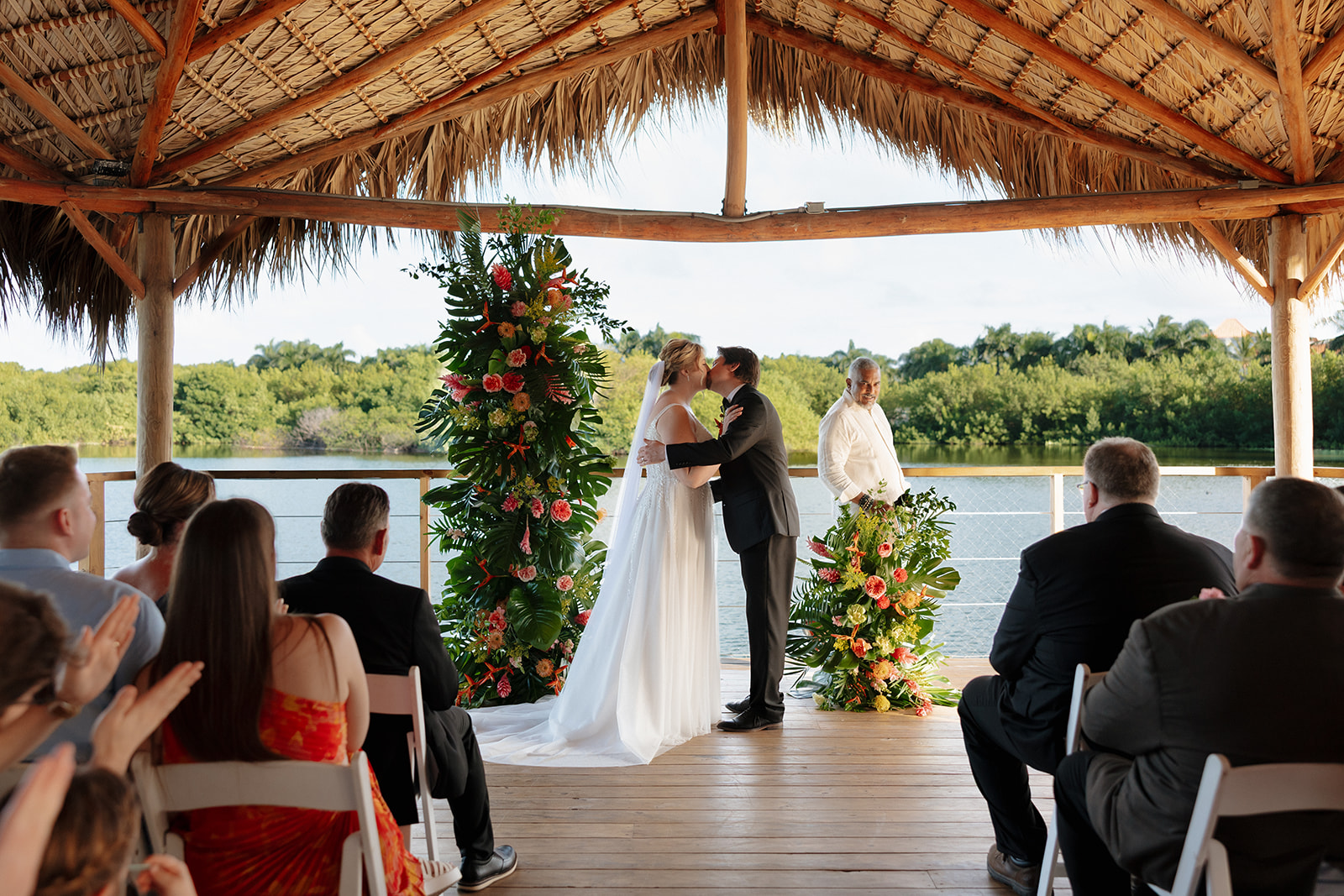 Bride and groom sharing their first kiss during a waterfront wedding ceremony in Florida
