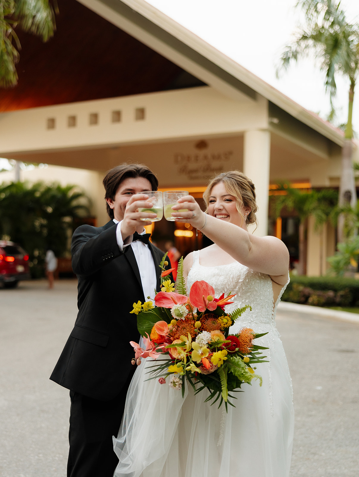 Newlyweds toasting drinks together outside their Florida wedding reception venue
