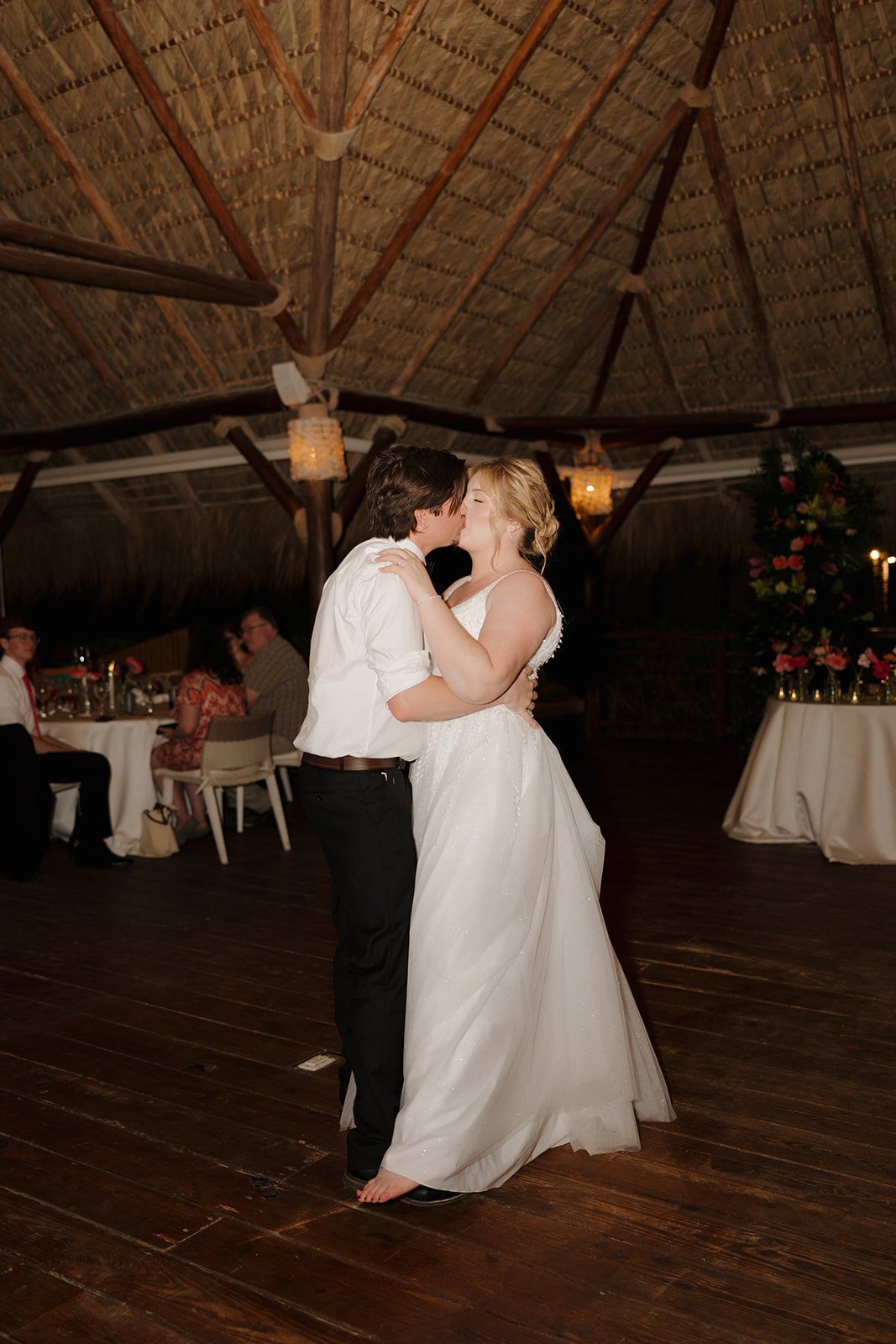 Romantic first dance moment between newlyweds during a tropical wedding reception in Florida
